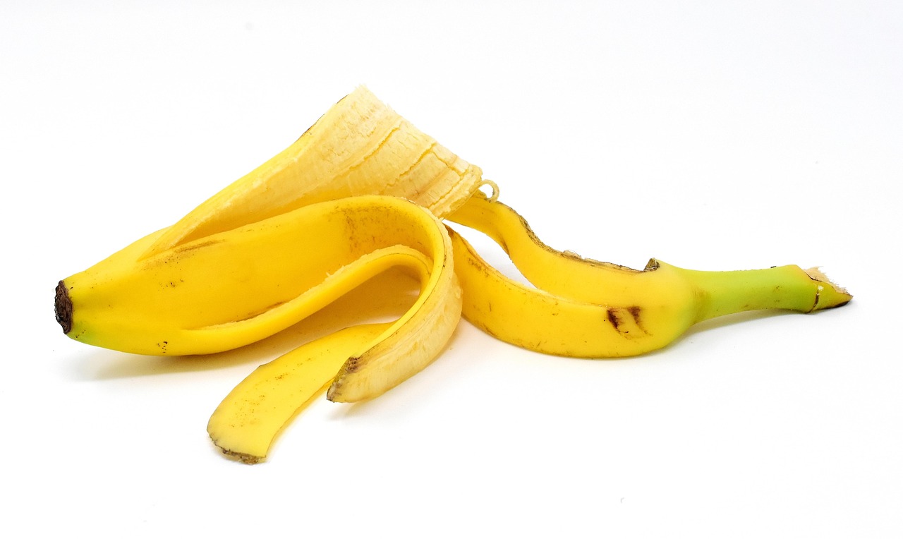 Buccia di banana nel vaso, circondata da terra e pianta, evidenziando gli effetti sul terreno e sulla vegetazione.